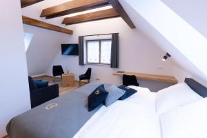 - une chambre avec un grand lit blanc et des oreillers bleus dans l'établissement Turizem Loka - Hotel Vila Loka, à Škofja Loka