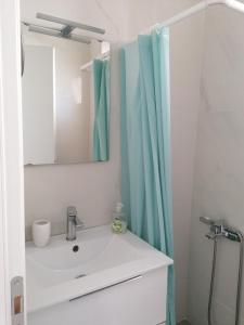 La salle de bains est pourvue d'un lavabo et d'un miroir. dans l'établissement Albina's luxury Villa 3 bedroom, à Chaniotis