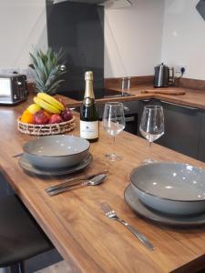 a wooden table with two glasses and a bottle of wine at south view farm cottage in Bradford