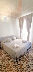 Un dormitorio con una cama grande con dos toallas encima. en Domus Maqueda, en Palermo