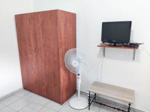 una camera con ventilatore accanto a un armadietto in legno di Aerinos House a Aërinós
