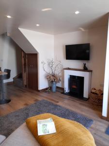 a living room with a fireplace and a flat screen tv at south view farm cottage in Bradford
