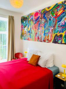 een slaapkamer met een rood bed en een schilderij aan de muur bij Green balcony & king size bed in Praag