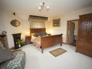 een grote slaapkamer met een bed en een open haard bij Beeches Farmhouse Country Cottages & Rooms in Bradford on Avon