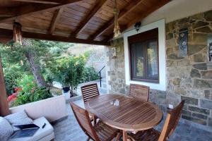 une table et des chaises en bois sur une terrasse dans l'établissement The Garden House, Sitia, à Siteía