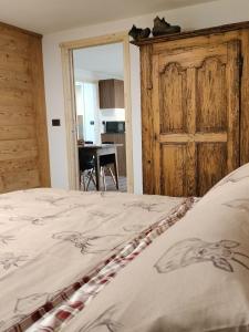 1 dormitorio con 1 cama y puerta de madera en Le chalet du village en Chambave