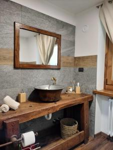 bagno con lavandino e specchio di Le chalet du village a Chambave