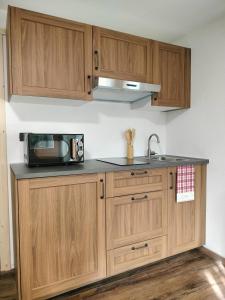 a kitchen with wooden cabinets and a microwave at Le chalet du village in Chambave