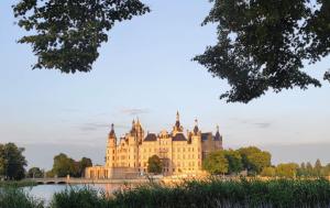 ein Schloss auf dem Wasser vor einer Brücke in der Unterkunft Ferienwohnung am Schweriner Außensee in Schwerin