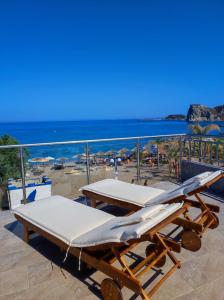 two beds on top of a balcony with a beach at Nostalgia Apartment in Archangelos