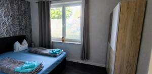 ein kleines Schlafzimmer mit einem Bett und einem Fenster in der Unterkunft Ferienwohnung am Schweriner Außensee in Schwerin