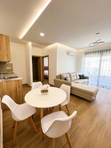 uma sala de estar com um sofá, uma mesa e cadeiras em Square Residence em Ulcinj
