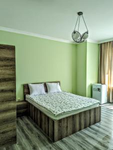 1 dormitorio con 1 cama grande y paredes verdes en Corner house en K'obulet'i