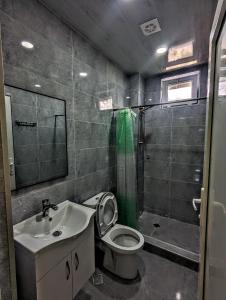 a bathroom with a toilet and a sink and a shower at Corner house in K'obulet'i