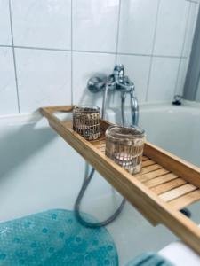 a bathroom with a wooden shelf next to a bath tub at Lidia Apartment in Celle