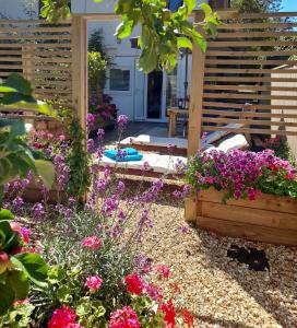 einen Garten mit Blumen und einer hölzernen Pergola in der Unterkunft Forest Palms Studio The New Forest National Park in Fordingbridge