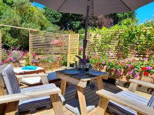 a patio with a table and two chairs and an umbrella at Forest Palms Studio The New Forest National Park in Fordingbridge +31 photos