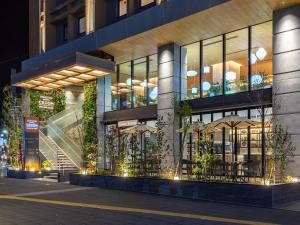 a large building with tables and umbrellas outside at night at Nishitetsu Hotel Croom Hakata Gion Kushida Shrine in Fukuoka