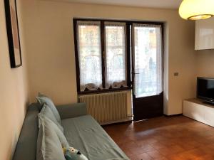 uma sala de estar com um sofá e uma janela em 051 Trilocale piano terra, Pinzolo em Pinzolo