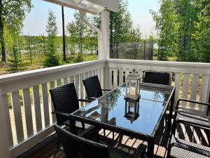 d'une terrasse avec une table en verre et des chaises. dans l'établissement Villa Aleksandra, LaatuLomat, à Juva