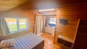 a small bedroom with a bed and a television at Vacation Without Make Up in Šventoji