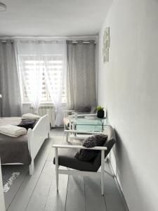 Sala de estar con 2 camas y mesa en Domek Mazury Pisz, en Pisz
