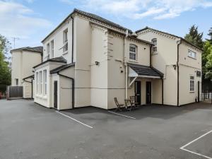 un grand bâtiment blanc avec un parking dans l'établissement Springhill Court, à Bewdley