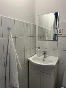 a white bathroom with a sink and a mirror at Domek Mazury Pisz in Pisz