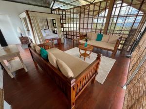 a living room with a large couch and a bed at The Farmhouse Mahaulpatha in Bandarawela