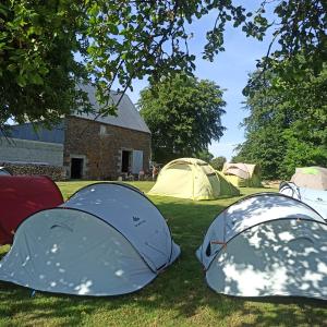 un groupe de tentes assises dans l'herbe dans l'établissement La Billardière Camping à la Ferme, à Le Ménil-Ciboult