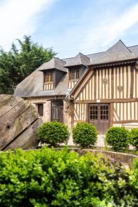 een groot huis met een gambrel dak bij Gites - Domaine de Geffosse in Pont-lʼÉvêque