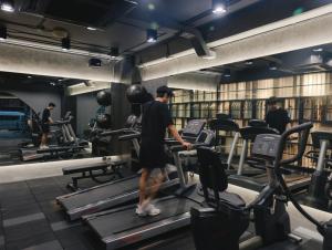 a man walking on a treadmill in a gym at Art Mai Gallery Nimman Hotel Chiang Mai in Chiang Mai