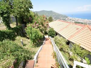 een uitzicht op een loopbrug met bomen en bloemen bij La casa di Enzo in Noli