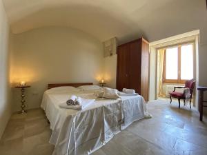 a bedroom with a white bed with towels on it at Masseria La Millenaria in San Foca