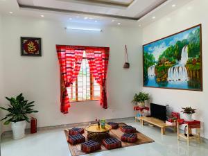 d'un salon avec une table et une peinture murale. dans l'établissement Pết house Mộc Châu, à Mộc Châu