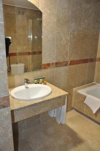 a bathroom with a sink and a tub at NEO HOTEL in Caravaca de la Cruz