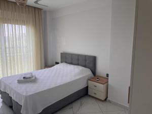 ein Schlafzimmer mit einem großen Bett und einem Fenster in der Unterkunft MAYA APARTMANI in Kusadası