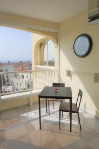 a dining room with a table and a clock on the wall at Golf del Sur Apartment - magnificent panorama of the ocean, el Teide, and Montaña Roja in San Miguel de Abona