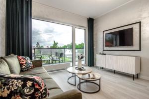 a living room with a couch and a large window at Willa La Maddalena ALLDAYHOLIDAY Mielno in Mielno