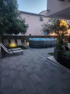 eine Terrasse mit 2 Stühlen und einem Pool in der Unterkunft Teodora holiday house seafront in Kaštela