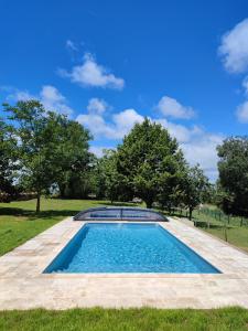 uma piscina num campo com árvores ao fundo em Au Grand Bonheur - Gîte Padirac - Rocamadour em Miers