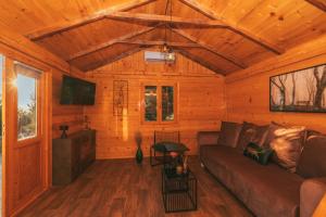 a living room of a wooden cabin with a couch at Tiny house Aria in Makarska