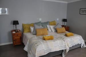 um quarto com uma cama com duas almofadas amarelas em Giraffe's Rest, Self Catering Studio Apartment em White River