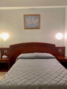 a bed in a bedroom with two tables and a picture on the wall at Hotel Sangro in Mozzagrogna +29 photos