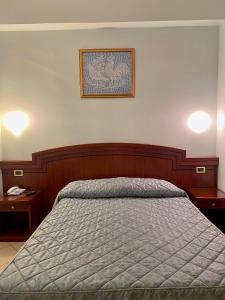 ein Bett in einem Schlafzimmer mit zwei Tischen und einem Bild an der Wand in der Unterkunft Hotel Sangro in Mozzagrogna