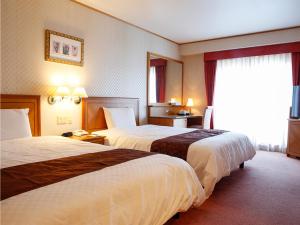 a hotel room with two beds and a window at Hotel BELLMARE ホテルベルマーレ in Maizuru