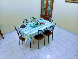einem Tisch mit Stühlen und einem blauen und weißen Tischtuch in der Unterkunft Homestay Rawang Gamuda Luge in Rawang