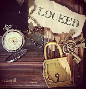 a lock and a key next to a clock and a key chain at Escap'Home - Appartement insolite - Enquête dans l'hébergement et option séance d'escape game le jour du départ in Friville-Escarbotin