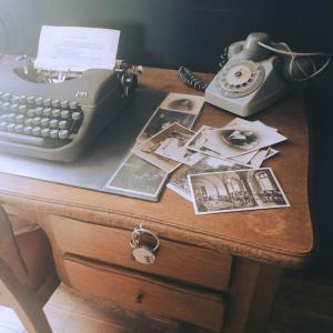 a desk with a phone and a typewriter on it at Escap'Home - Appartement insolite - Enquête dans l'hébergement et option séance d'escape game le jour du départ in Friville-Escarbotin