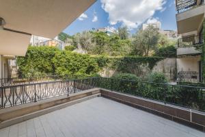 a balcony of a building with bushes and trees at Hotel & Apartments HEC Residence in Sveti Stefan